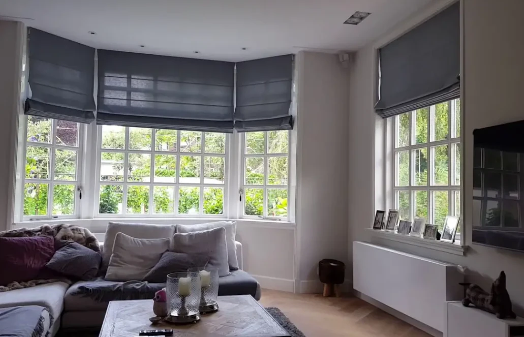 Blauwgrijze elektrische vouwgordijnen in een woonkamer gekoppeld aan domotica