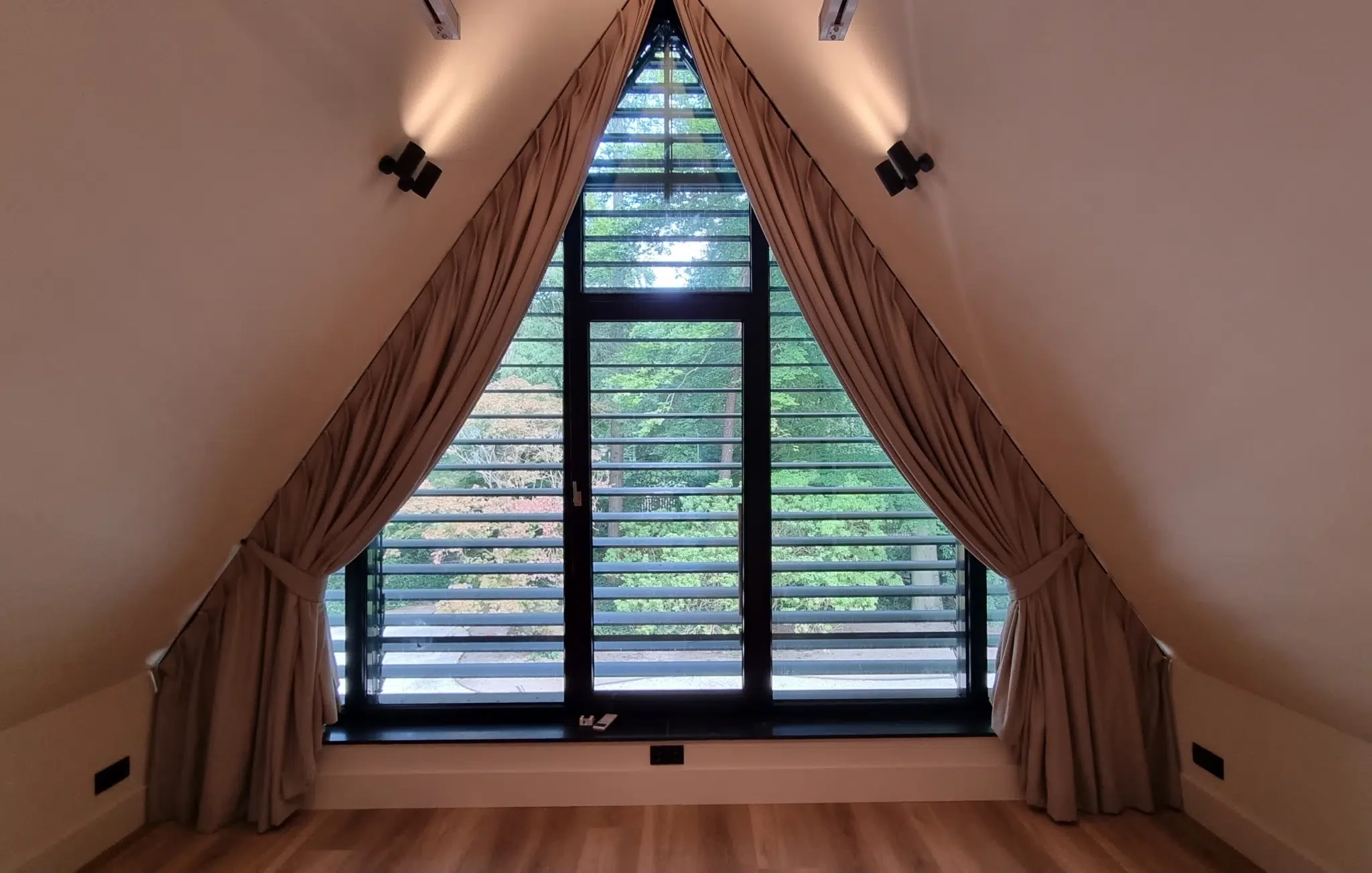 Schuine gordijnen in een puntraam binnen het KNX woningproject