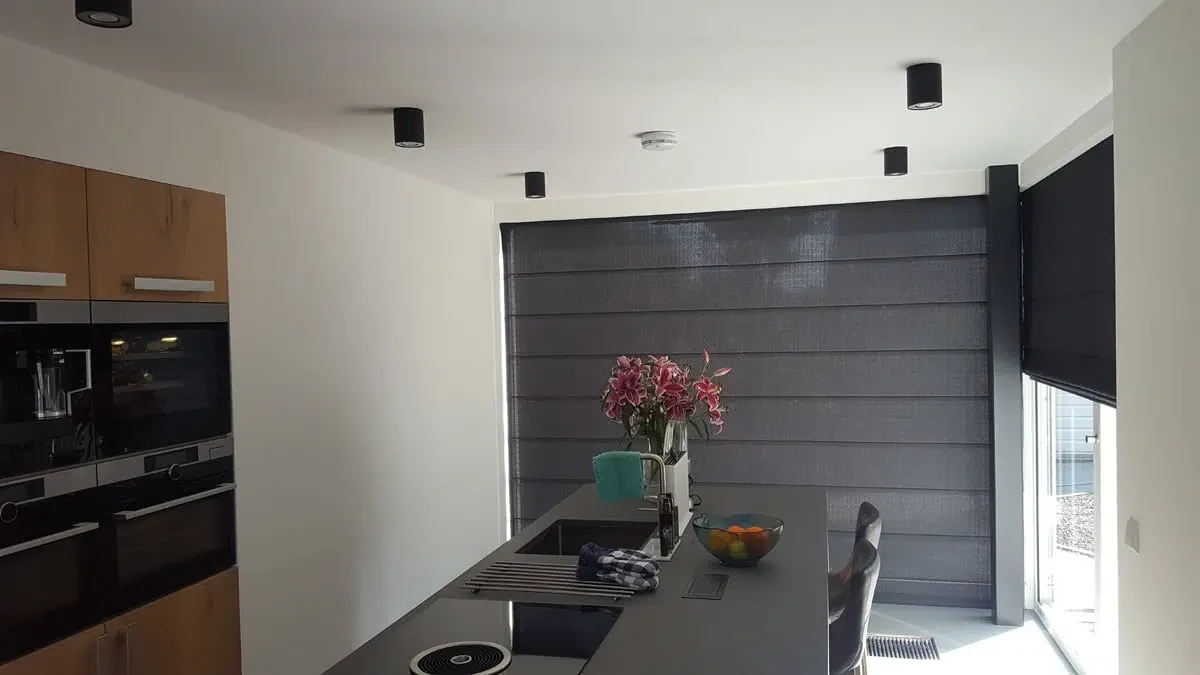 Donkergrijs vouwgordijn in moderne keuken met kookeiland