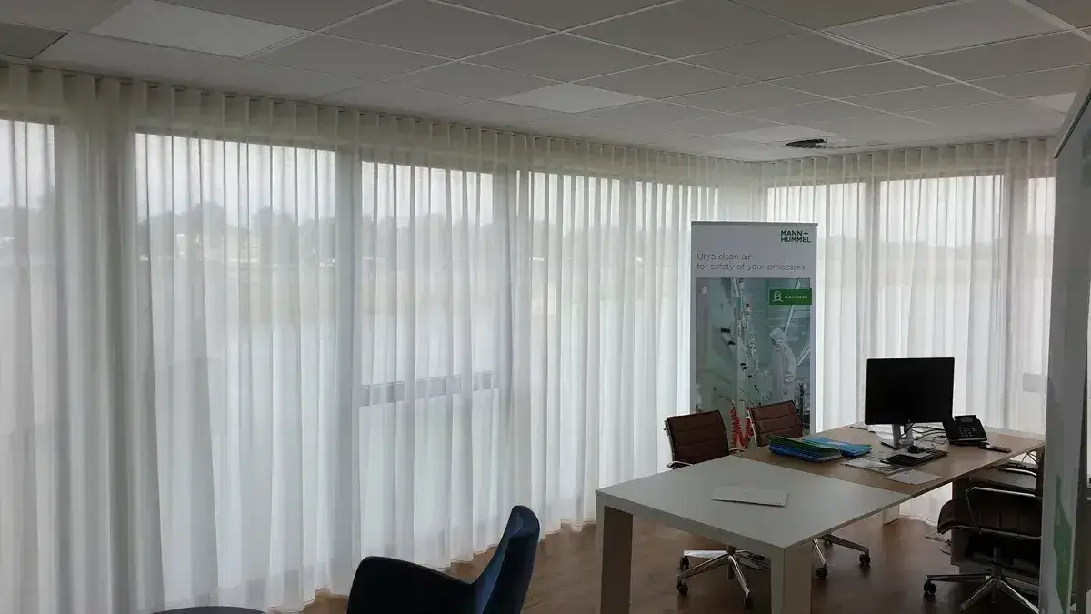 Vitrage met wave plooi aan een plafondrail