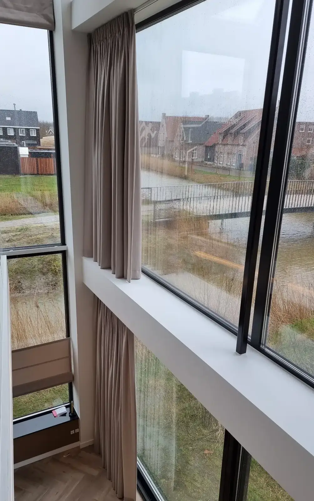 Gordijnen boven elkaar bij een hoge glaspartij over twee verdiepingen