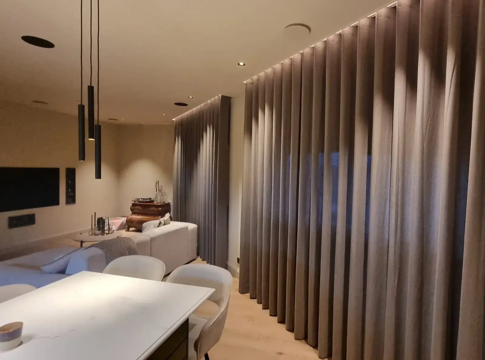 Gordijnen die vanuit een plafondkoof naar beneden vallen in een woonkamer