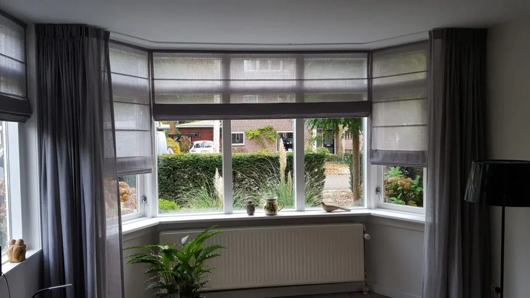 Gebogen gordijnrail door een erker