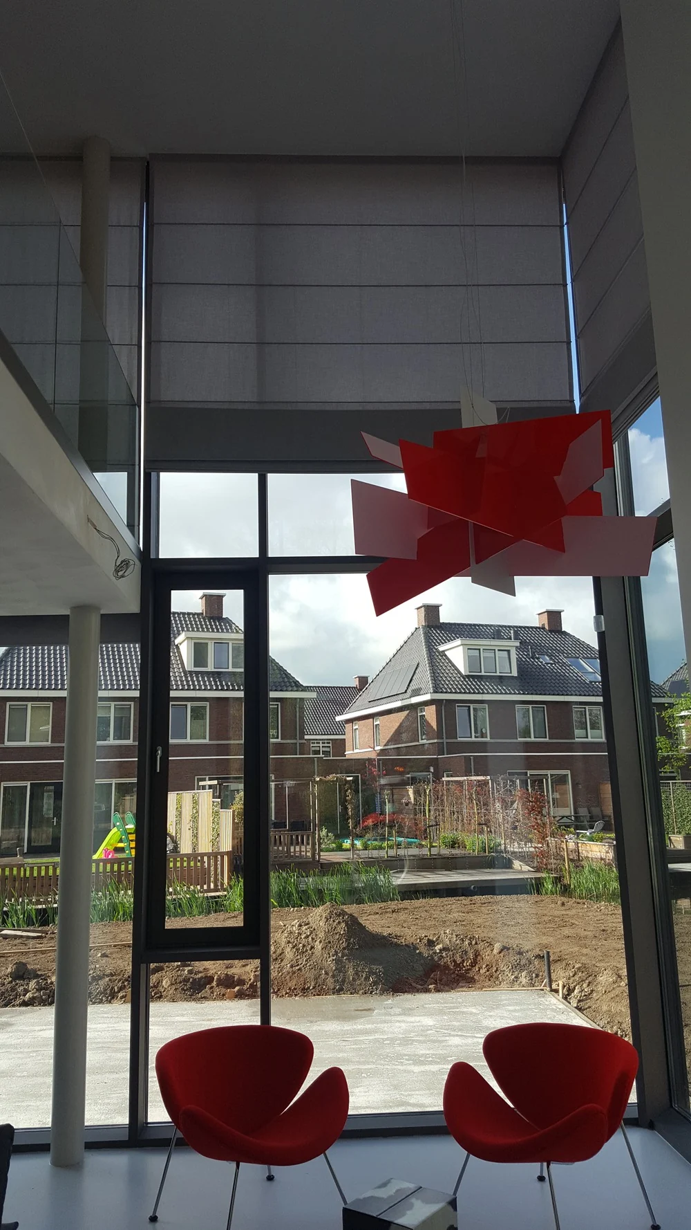 Hoog elektrisch vouwgordijn in een woning met vide