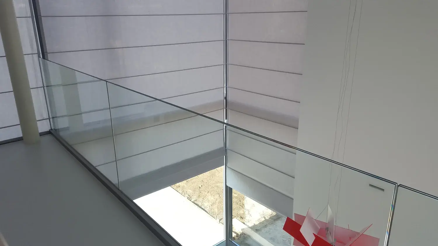 Hoge vouwgordijnen in een vide van een moderne woning
