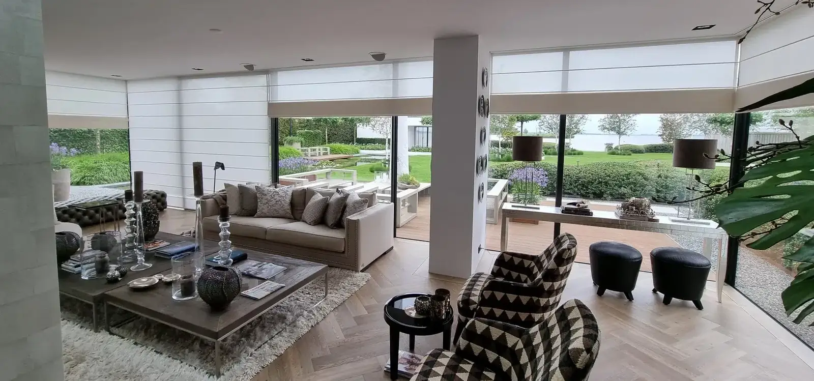 Lichte vouwgordijnen in een woonkamer met brede glaspartijen