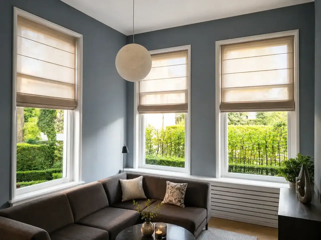 Beige vouwgordijnen op smalle hoge ramen met blauwe wand