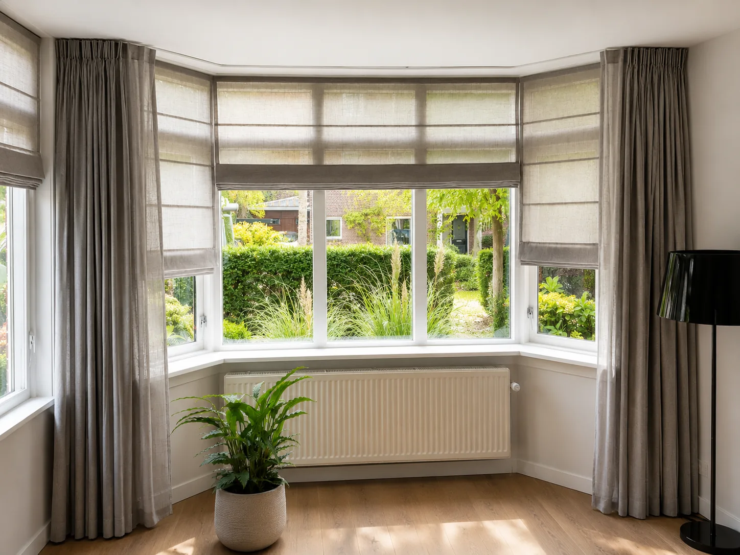 Lichtgrijze gordijnen in een erker