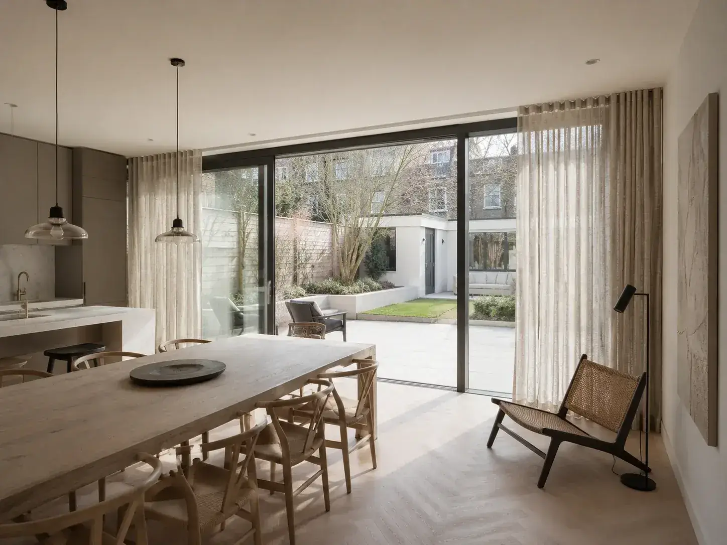 Lichte wave gordijnen op maat aan een brede glazen pui
