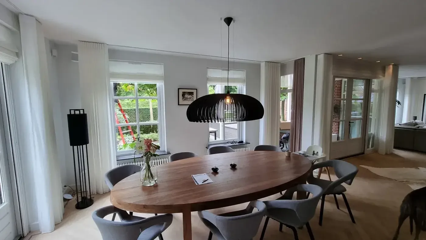 Witte vouwgordijnen met lange gordijnen in een moderne woonkamer