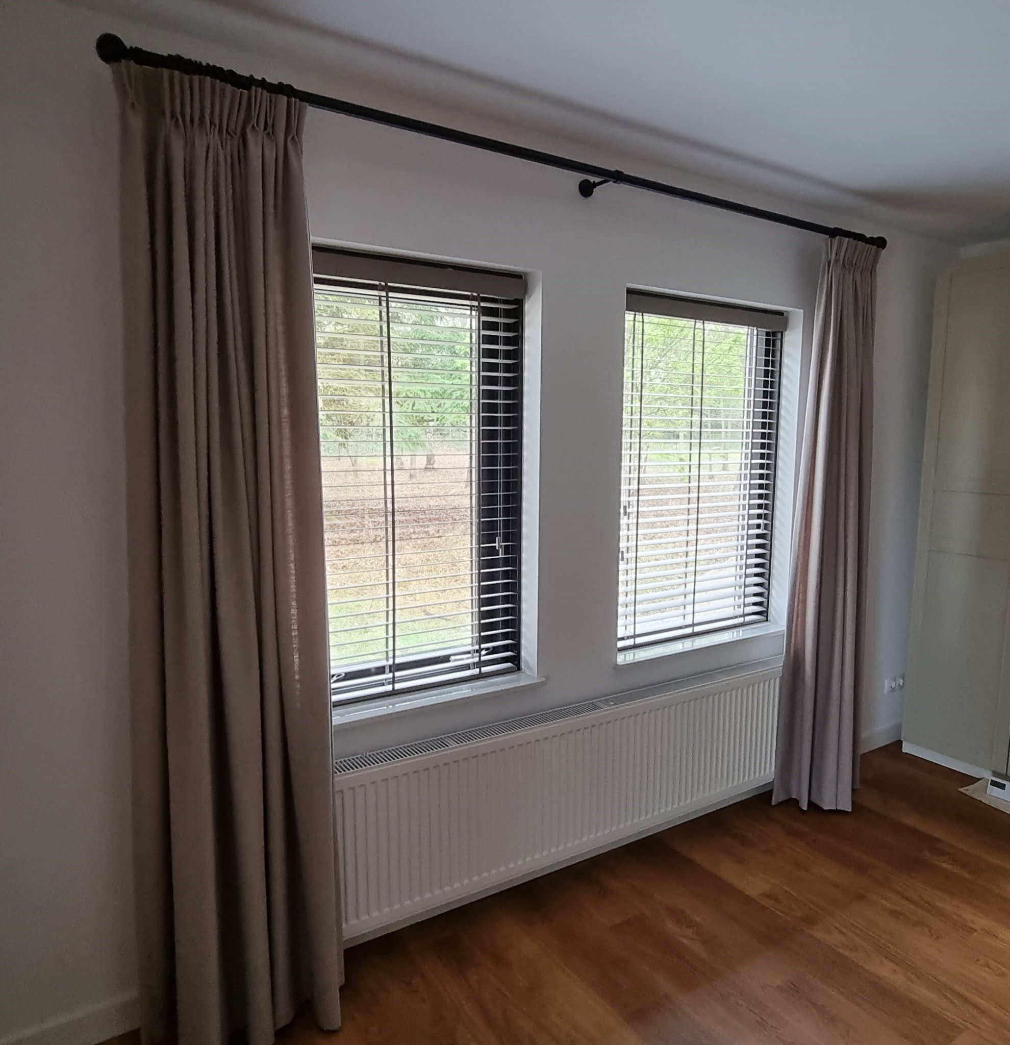 Zwarte-gordijnroede-met-dubbele-plooi-gordijnen Houten jaloezie met gordijnroede zwart